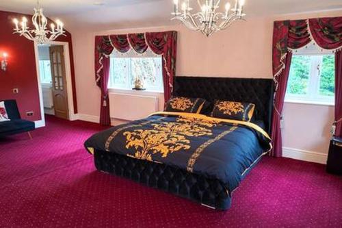 a bedroom with a large bed with purple carpet at Stratford 4 BR Family Mansion with Pool, Gym BBQ in Henley in Arden