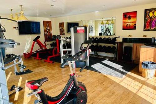 a room with a gym with a scooter in it at Stratford 4 BR Family Mansion with Pool, Gym BBQ in Henley in Arden