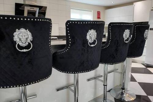 three black chairs sitting in a kitchen at Stratford 4 BR Family Mansion with Pool, Gym BBQ in Henley in Arden