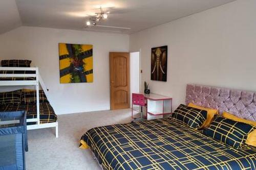 a bedroom with a bed and a bunk bed at Stratford 4 BR Family Mansion with Pool, Gym BBQ in Henley in Arden
