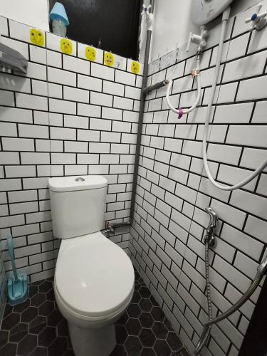 a bathroom with a white toilet and a hose at Simee 2 pax Room Stay in Gua Sai