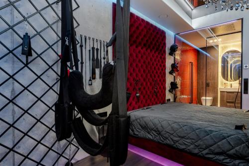 a room with a bed with a red wall at 69 Fetish Apartments with Free Underground Parking in Kaunas