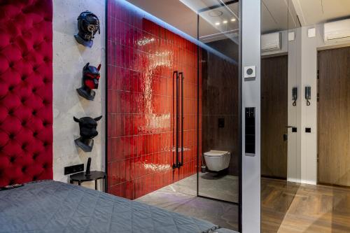 a bedroom with a red wall with a toilet at 69 Fetish Apartments with Free Underground Parking in Kaunas