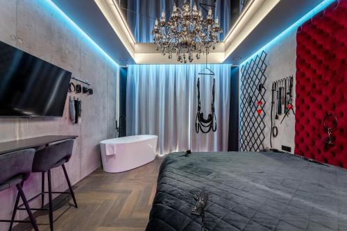 a bedroom with a bed and a sink and a chandelier at 69 Fetish Apartments with Free Underground Parking in Kaunas