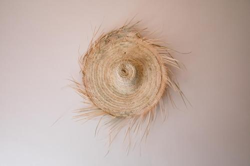 a piece of hay hanging on a white wall at Appartement Dar Tamraght in Tamraght Ouzdar