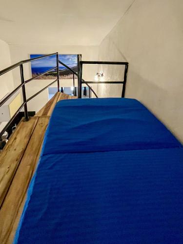 a bedroom with a blue bed with a view of the ocean at Ocean Lovers Taganga - PADI Dive Center & Hostel in Taganga