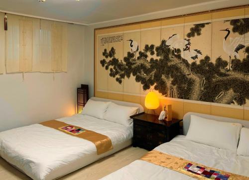 a bedroom with two beds and a painting on the wall at Arisu Sauna House 전철역2초#3BR#공항픽업#사우나#롯데월드#잠실#장박할인#Kspo#올림픽공원#명동#아산병원 in Seoul