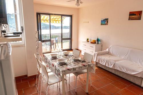 a living room with a table and a couch at Giglio Blu 5 in Isola del Giglio