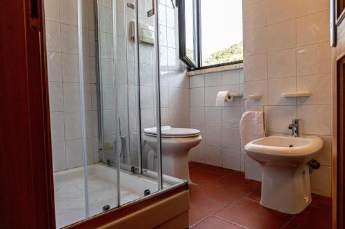 a bathroom with a shower and a toilet and a sink at Giglio Blu 5 in Isola del Giglio