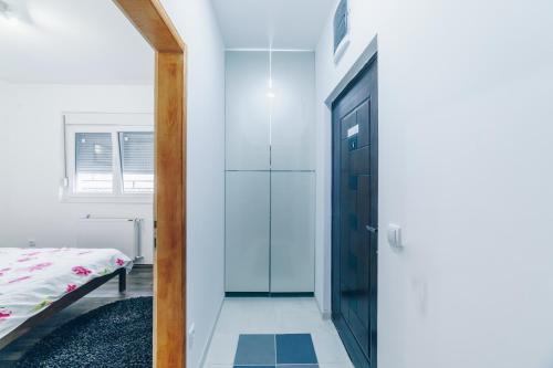 a hallway with a glass door leading to a bedroom at Sreckovic Apartmani 2 in Kragujevac