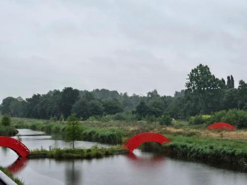 two red bridges over a river in a field at Villa Suite Oudshoorn in Alphen aan den Rijn