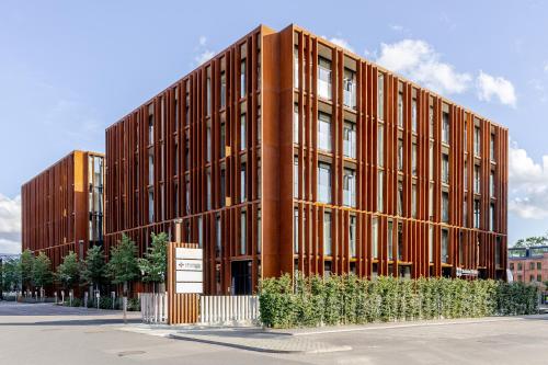 a large brick building with trees in front of it at 69 Fetish Apartments with Free Underground Parking in Kaunas