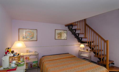 a bedroom with a bed and a spiral staircase at Hotel Rex in Lucca