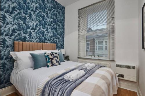 a bedroom with a large bed with a blue wallpaper at 4 bedroom, 6 beds, 10 guest, Free parking on site in Elswick