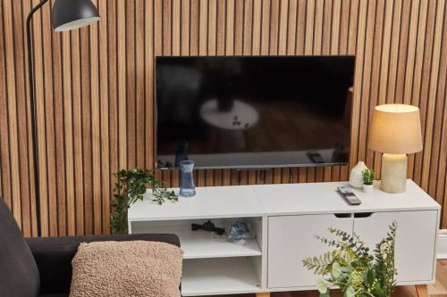 a living room with a television on a white table at 4 bedroom, 6 beds, 10 guest, Free parking on site in Elswick