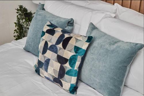two blue pillows on a white couch at 4 bedroom, 6 beds, 10 guest, Free parking on site in Elswick