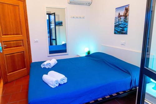 a bedroom with a blue bed with towels on it at Giglio Blu 1 in Campese