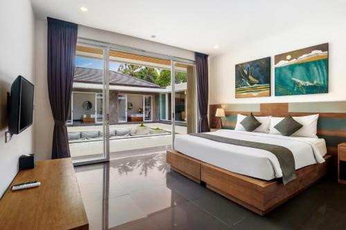 a bedroom with a large bed and a large window at Villa Dune in Ubud