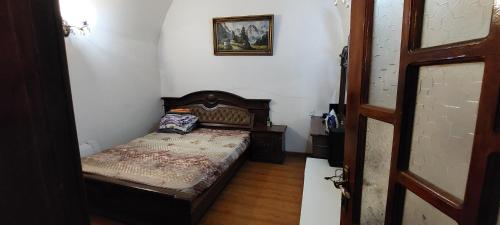 una piccola camera da letto con un letto e un quadro sul muro di квартира a Baku
