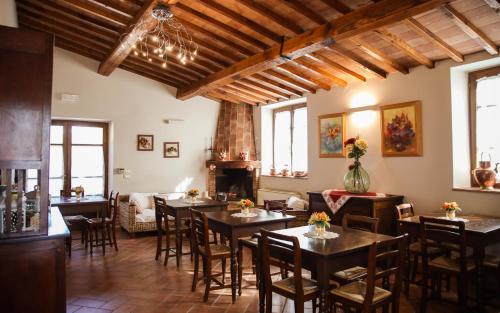 a restaurant with tables and chairs and a fireplace at Agriturismo La Vecchia Quercia in Montemerano