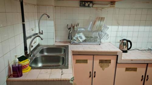 a dirty kitchen with a sink and a counter at Homestay Kuala Lumpur in Kuala Lumpur