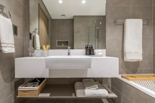 a bathroom with a white sink and a shower at District One Dubai Lagoon View Near Downtown in Dubai