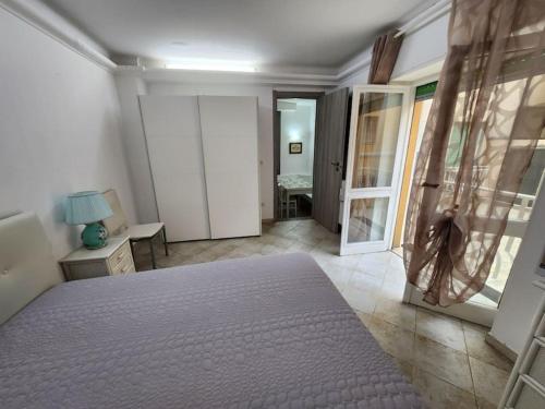 a bedroom with a bed and a room with a table at Vico Sant Erasmo Alassio in Alassio