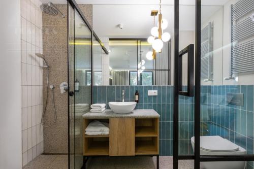a bathroom with a sink and a shower at Fragola Apartments Vistula View in Kraków