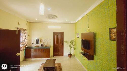 a living room with green walls and a tv at AAK Hills stay villa in Kodaikānāl