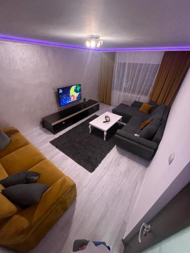 a living room with a couch and a tv at Relax Loft in Oradea