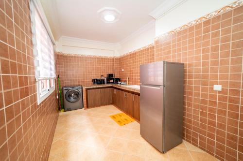 a kitchen with a refrigerator and a washer and dryer at Appartement Dar Tamraght in Tamraght Ouzdar