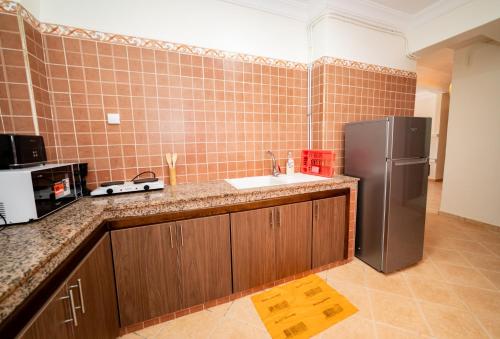 a kitchen with a sink and a refrigerator at Appartement Dar Tamraght in Tamraght Ouzdar