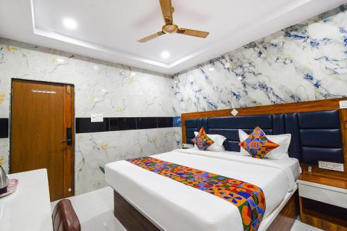 a bedroom with a bed with a blue and white wallpaper at Hotel Sooryoday Palace in Hyderabad