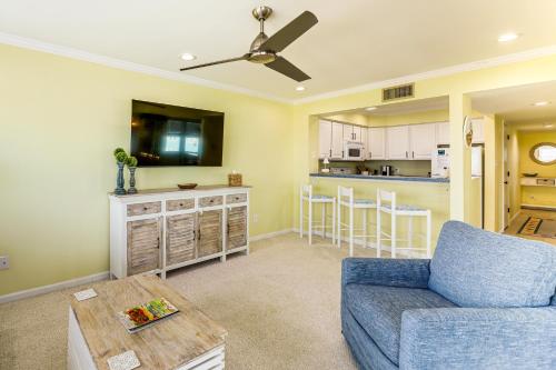 a living room with a blue couch and a kitchen at Marina Views, Walk to Beach Atlantic Beach Condo! in Atlantic Beach