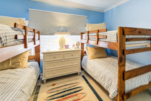 a bedroom with two bunk beds and a night stand at Marina Views, Walk to Beach Atlantic Beach Condo! in Atlantic Beach