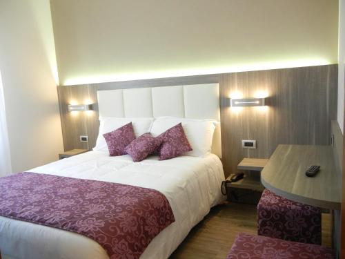 a bedroom with a large bed with purple pillows at Delle Nazioni Milan Hotel in Milan