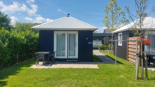 a blue house with a table and chairs in a yard at Recreatie aan de Vecht, Hooibergje 3, Weesp in Weesp