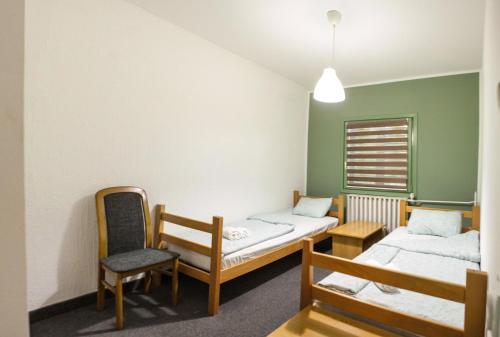 a room with two beds and a chair and a window at Gorski vrt in Novi Sad