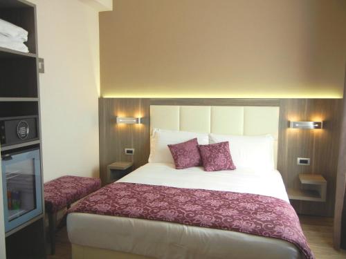 a hotel room with a large bed with purple pillows at Delle Nazioni Milan Hotel in Milan