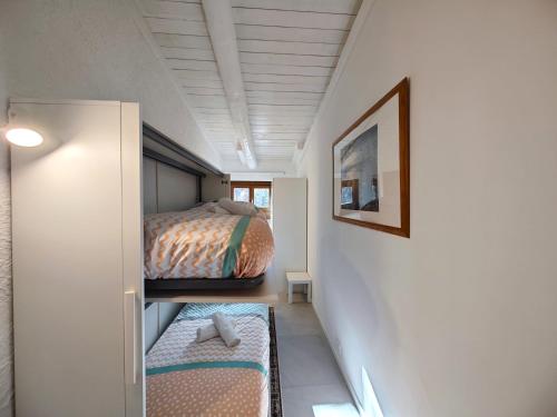 a small bedroom with two beds and a hallway at Hostdomus - Stella Alpina in Pragelato