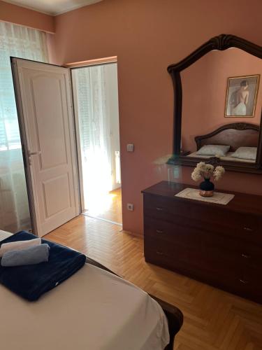 a bedroom with a bed and a mirror and a dresser at Luxury Apartment in Mladenovac