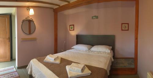 a bedroom with a bed with two towels on it at Nar Bağevi in Bozcaada
