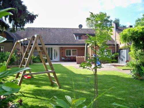 a garden with a wooden swing set in the yard at Pension Wendler in Bedburg