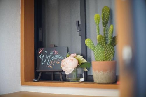 a plant and a vase with a flower on a shelf at Ueno Hoshi-5 minutes from Iriya Station-1 stop from Ueno station in Tokyo