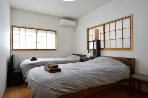 a room with two beds and two windows at Ueno Hoshi-5 minutes from Iriya Station-1 stop from Ueno station in Tokyo