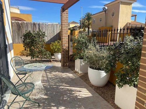 a patio with a table and chairs and potted plants at Villa Marysol in Mazarrón
