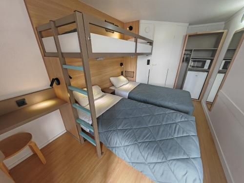 a small room with two bunk beds and a chair at Premiere Classe Lille Sud - Douai Cuincy in Cuincy
