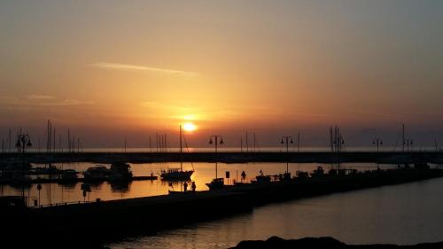 a sunset over a harbor with boats in the water at La Luna Blu in Agropoli