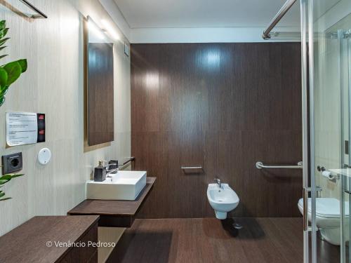 a bathroom with a sink and a toilet at Ericeira Coxos Beach Lodge in Santo Isidoro