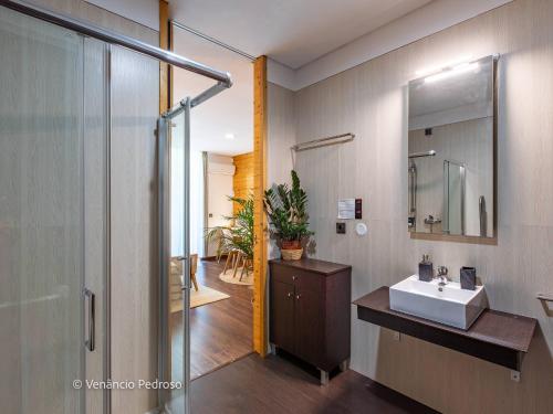 a bathroom with a sink and a shower and a mirror at Ericeira Coxos Beach Lodge in Santo Isidoro
